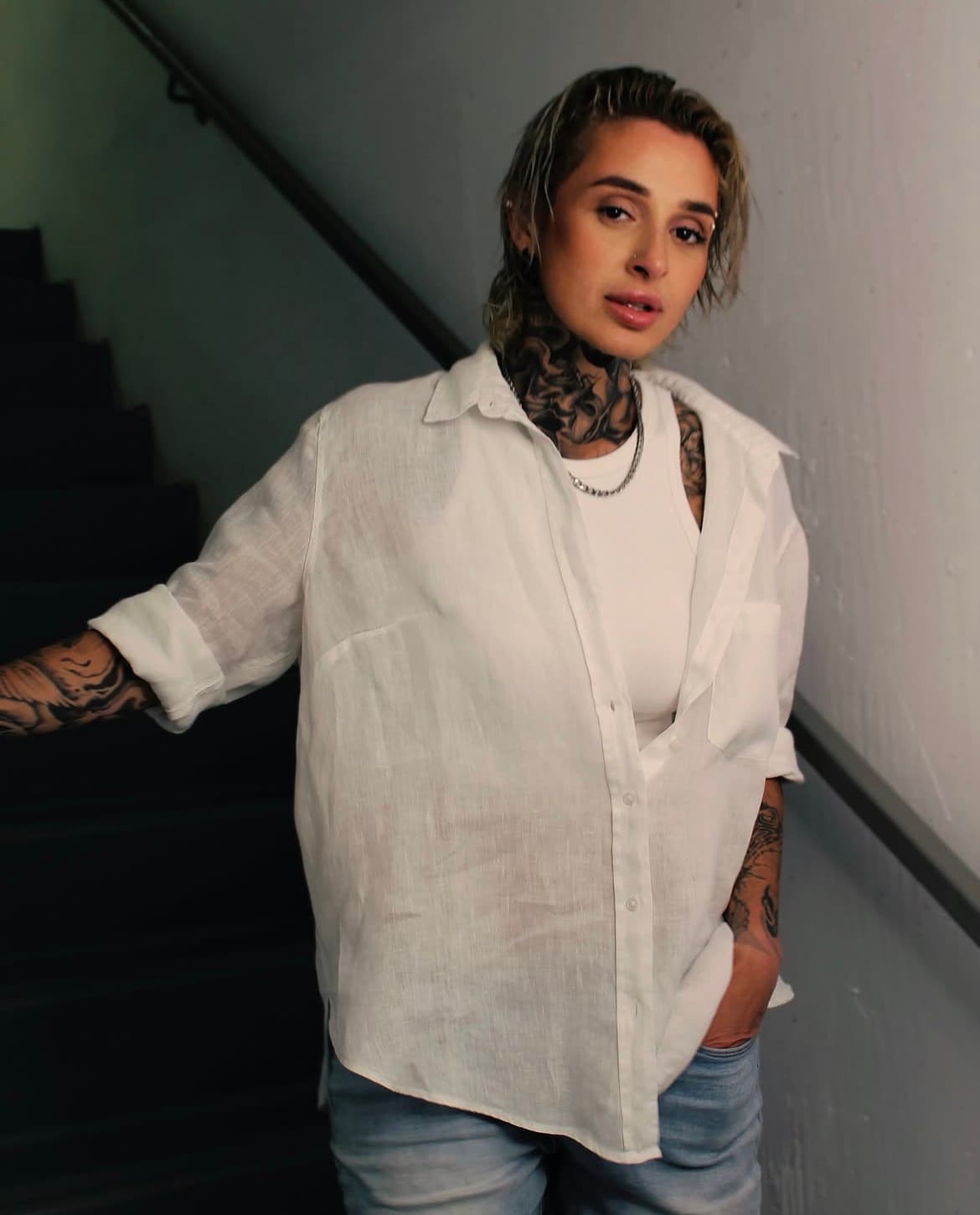 Stairwell portrait in white linen with a clean, camera-ready natural glam